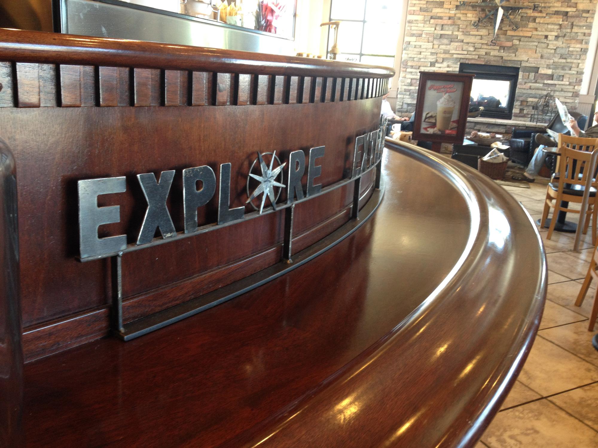 Metal Explore Extraordinary sign at flagship Lacey coffee shop