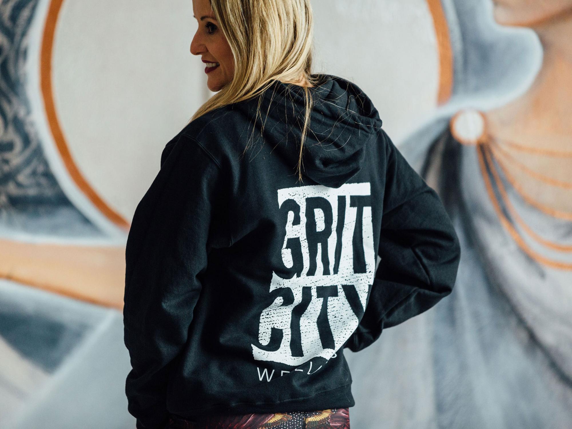 Woman wearing a Grit City Wellness hoodie